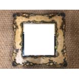 A contemporary wall mirror in broad parcel-gilt and painted wooden frame with applied floral and