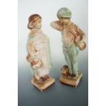 A pair of mid-20th Century kitsch plaster figurines modelled a young boy and girl, entitled "I