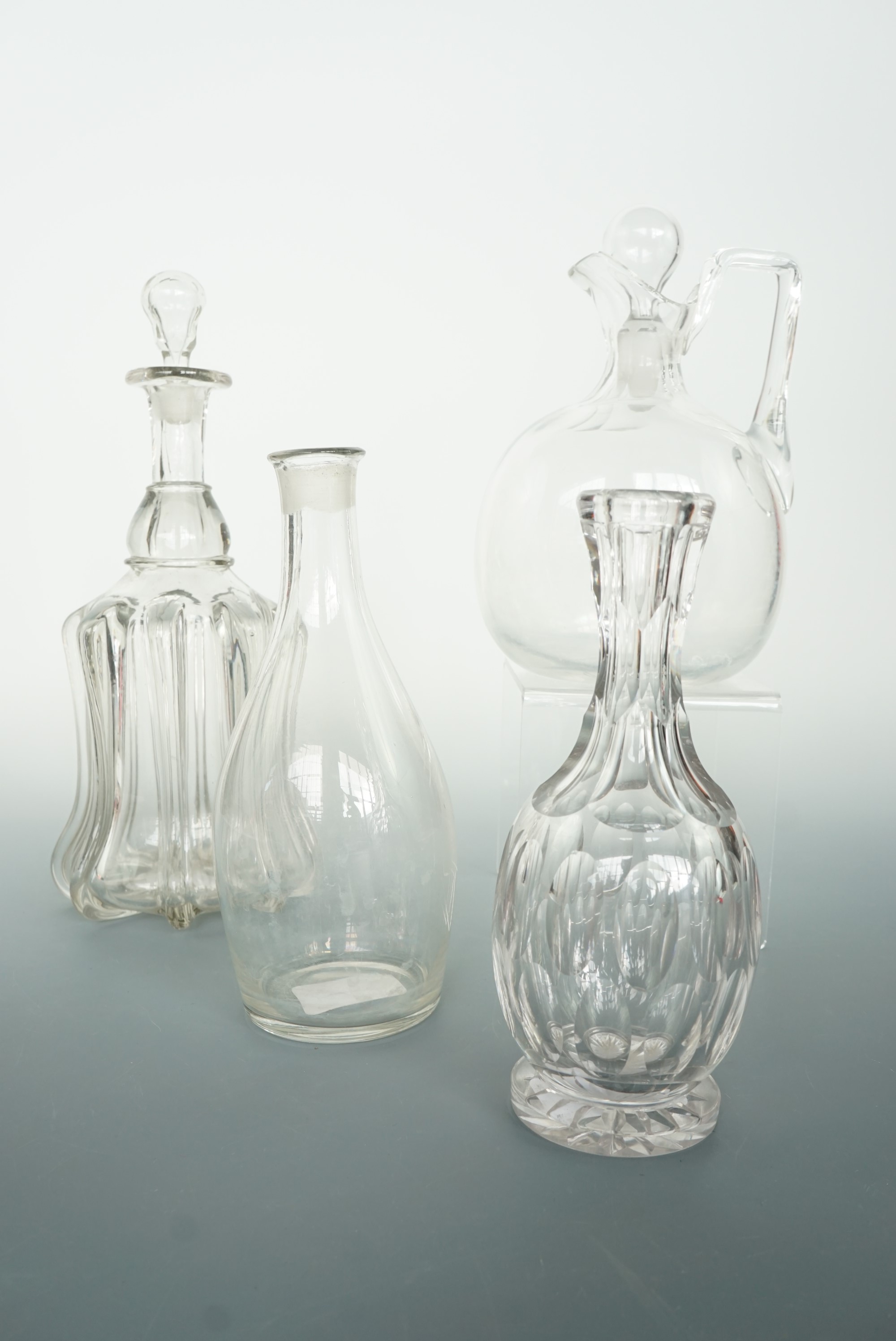 A Georgian glass decanter of Indian club form, a Victorian claret jug, ribbed-bell decanter and