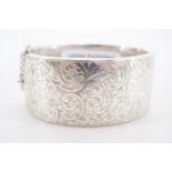 A silver hinged bangle, bearing engraved foliate scroll decoration, Birmingham, 1948