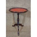 A reproduction mahogany tripod wine / lamp table with gilt-tooled leather top