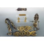 Horse brasses, a bell and two brass figurines, three brass chestnut rosters, a brass skimmer etc.