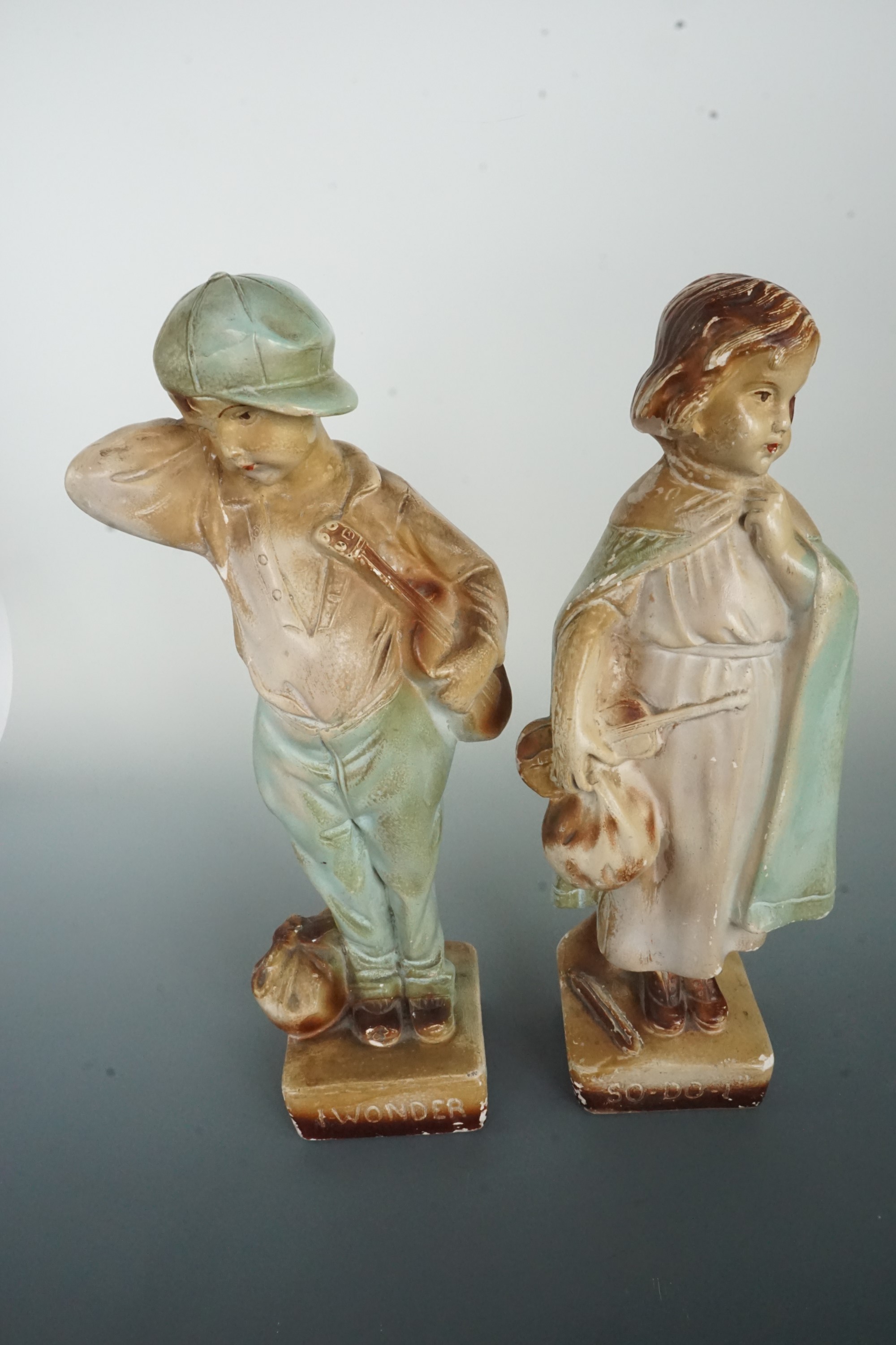 A pair of mid-20th Century kitsch plaster figurines modelled a young boy and girl, entitled "I - Image 2 of 3