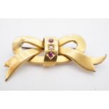 An antique 15ct gold brooch in the form of a ribbon bow, set with a seed pearls and rubies, 4 cm,