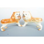 A pair of early 20th Century Staffordshire pottery lions, modelled standing and having glass eyes,