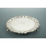 A George III silver waiter / card tray, having Chippendale border, raised over three volute feet,