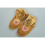 A pair of Native North American Cree Indian buckskin moccasins, having floral-embroidered vamps