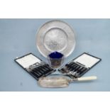An electroplate wall plaque, 29 cm diameter, two cased sets of spoons, a silver button hook, crumb