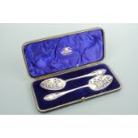 A cased pair of Victorian silver fruit serving spoons, pierced, engraved and bright-cut with