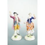 A pair of 18th Century style porcelain figurines, modelled as a young man and woman, each grasping a