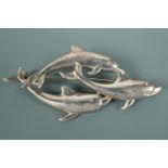 A contemporary white metal brooch modelled as three dolphins swimming, 6 cm