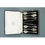 A cased set of six silver tea spoons and sugar tongs retailed by Hamilton and Inches, T Land &