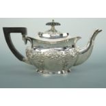 A George V silver bachelor's tea pot, of Georgian shape, lobed and repousse moulded with C scrolls