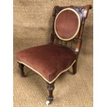 A Victorian upholstered mahogany nursing chair with a spindle back
