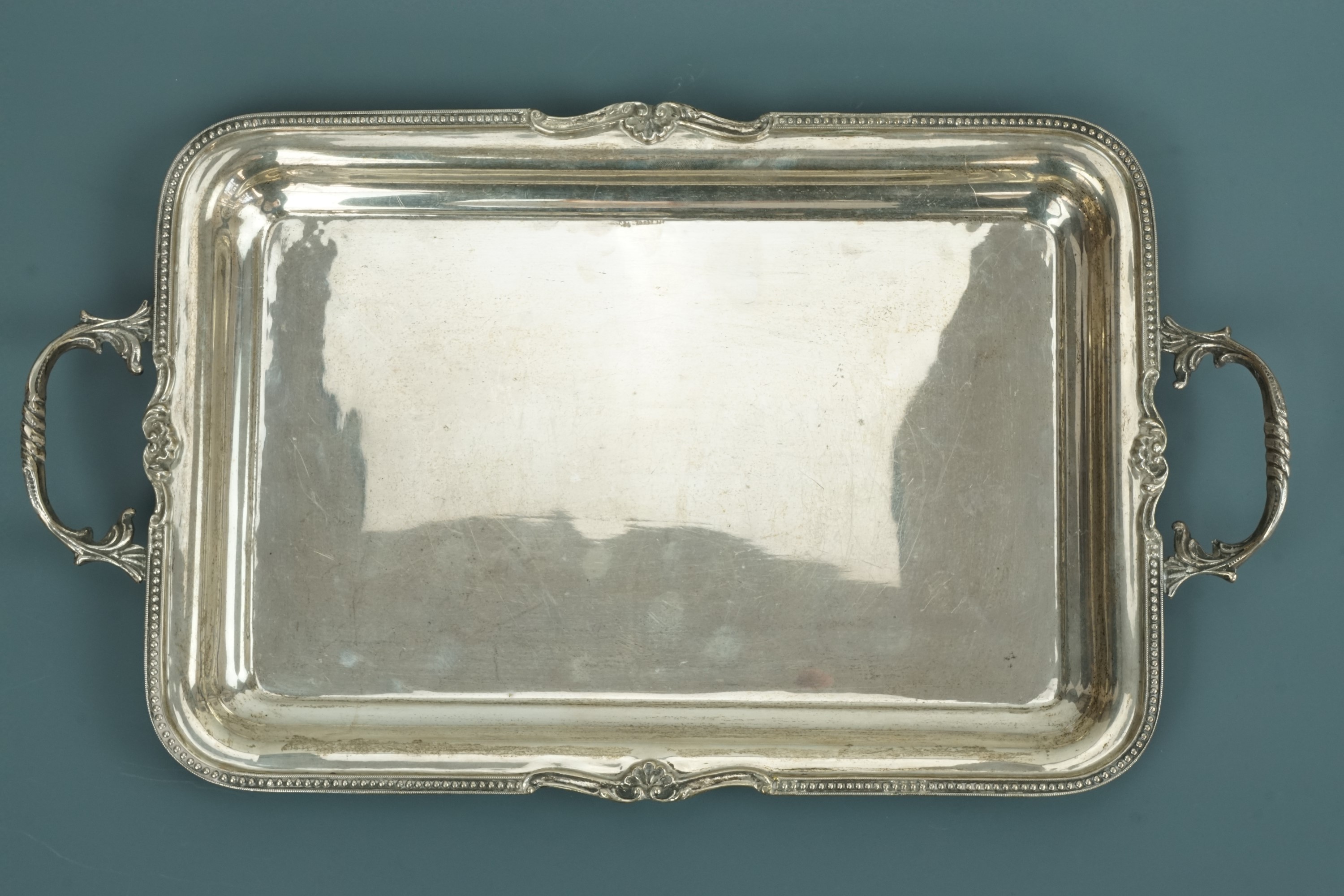 A white metal two handled tray, with scallop shell and bead border, stamped '925', tested as silver,