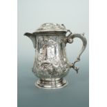 A Victorian silver lidded jug, of baluster form decorated with Rococo style C-scrolls, blossom and