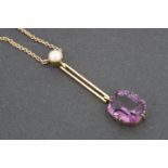 An early 20th Century yellow-metal, pearl and amethyst coloured glass pendant necklace, having a