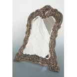 A late Victorian silver-faced dressing table mirror, decorated in a dense Rococo foliate and