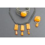 Latvian amber jewellery, including a base metal bangle with large amber nodule, a conforming pendant
