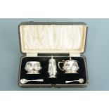 A George VI cased silver condiment set, the cruets having Celtic-influenced interlaced bands, Deakin