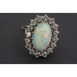 An impressive high carat white metal, diamond and opal cocktail ring, in a flower head cluster