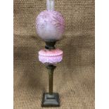 A Victorian brass columnar oil lamp with pink reservoir, 72 cm high