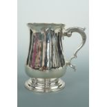A George III silver tankard, of baluster form with double C scroll handle and stepped circular foot,