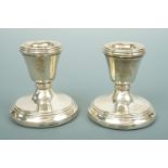 A pair of Elizabeth II silver diminutive candle sticks, with inverted bell-form sockets and reeded