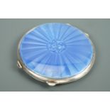 A George VI enamelled silver powder compact, of lenticular form, the face pale blue basse tailles