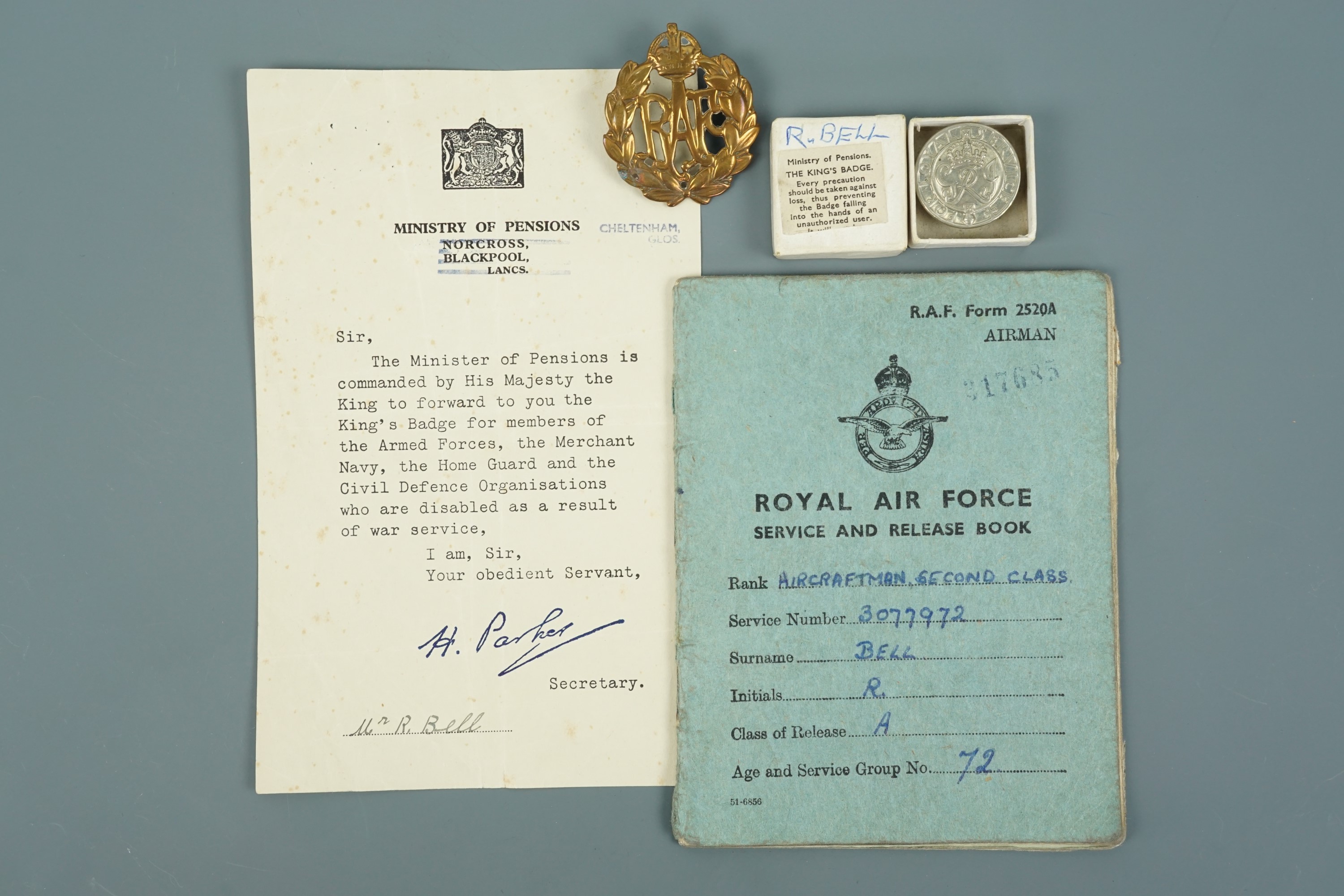 A 1940s RAF Service & Release Book together with cap badge, King's Badge and issue document