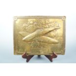 A Second World War embossed brass plaque depicting an RAF Spitfire, 23 cm x 30 cm