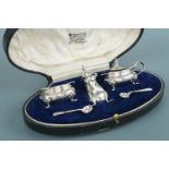 A cased George V silver cruet set, comprising salt cellar, pepper pot, mustard, and spoons,