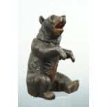 An antique Black Forest carved ink well in the form of a bear, 22 cm