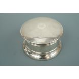 A silver drum form box, the cover having engine-turned decoration surrounding a central monogram,