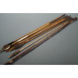 A collection of antique bamboo arrows, including examples with bodkin and variously barbed heads,