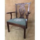A George III mahogany dining armchair, having a yoke back with lattice splat, scroll arms and