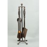 A wrought iron fireside companion set, 54 cm high