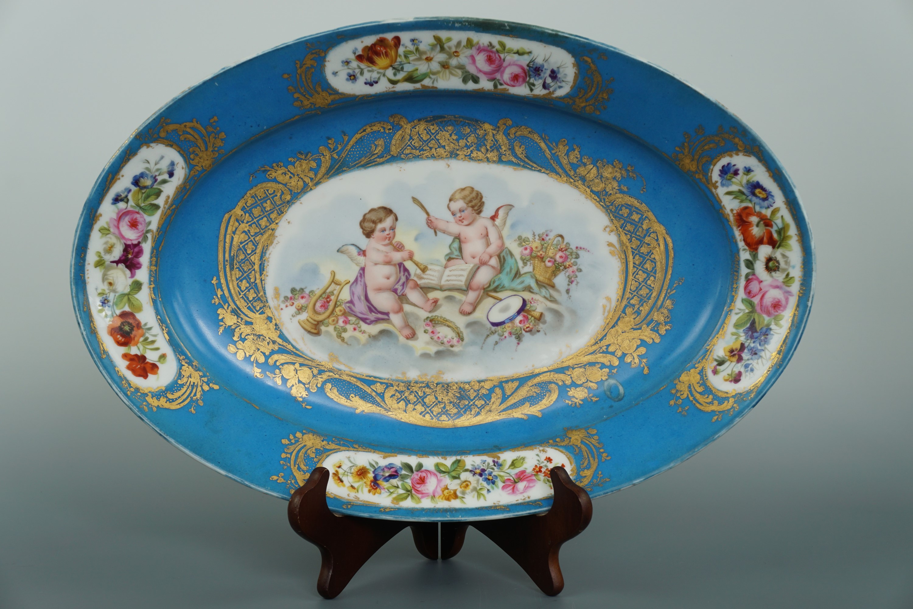 A 19th Century Sevres porcelain oval service dish, decorated in depiction of cupids with musical