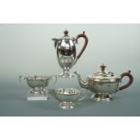 A George V silver four piece tea service, the tea pot, sugar and milk of hemispherical form, the hot