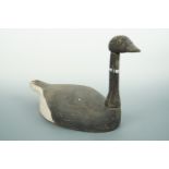 A 19th Century carved and painted pine goose decoy, having glass eyes, 50 cm x 29 cm high