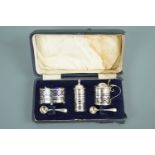 A George V cased silver cruet set, with reticulated geometric decoration of both a linear and spiral