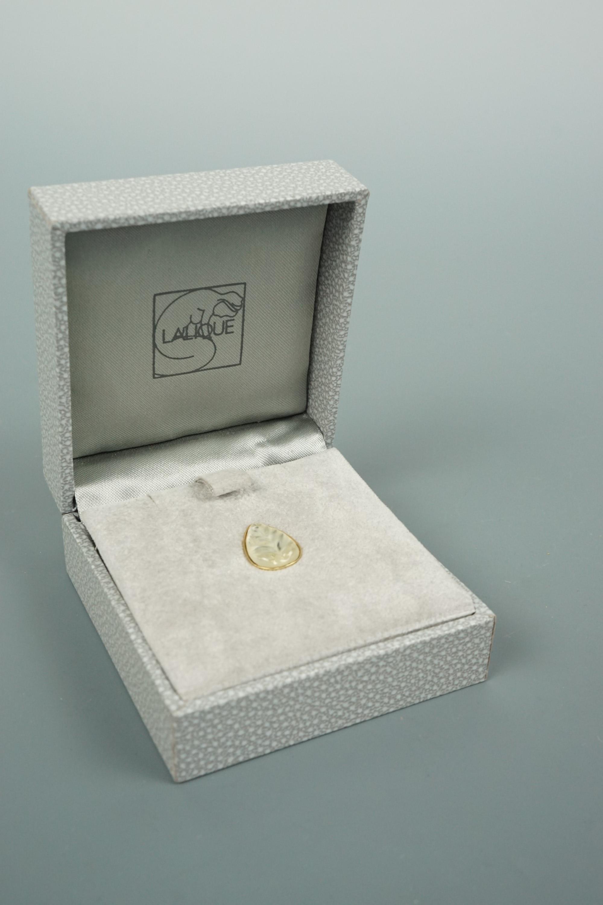 A Lalique crystal stud in the form of a leaf, gold plated, in original presentation box