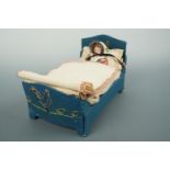 An early 20th Century hand made dolls bed of blue cloth embroidered with hens and chicks, with