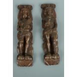 A pair of 17th Century style carved oak male and female figural furniture ornaments, modelled