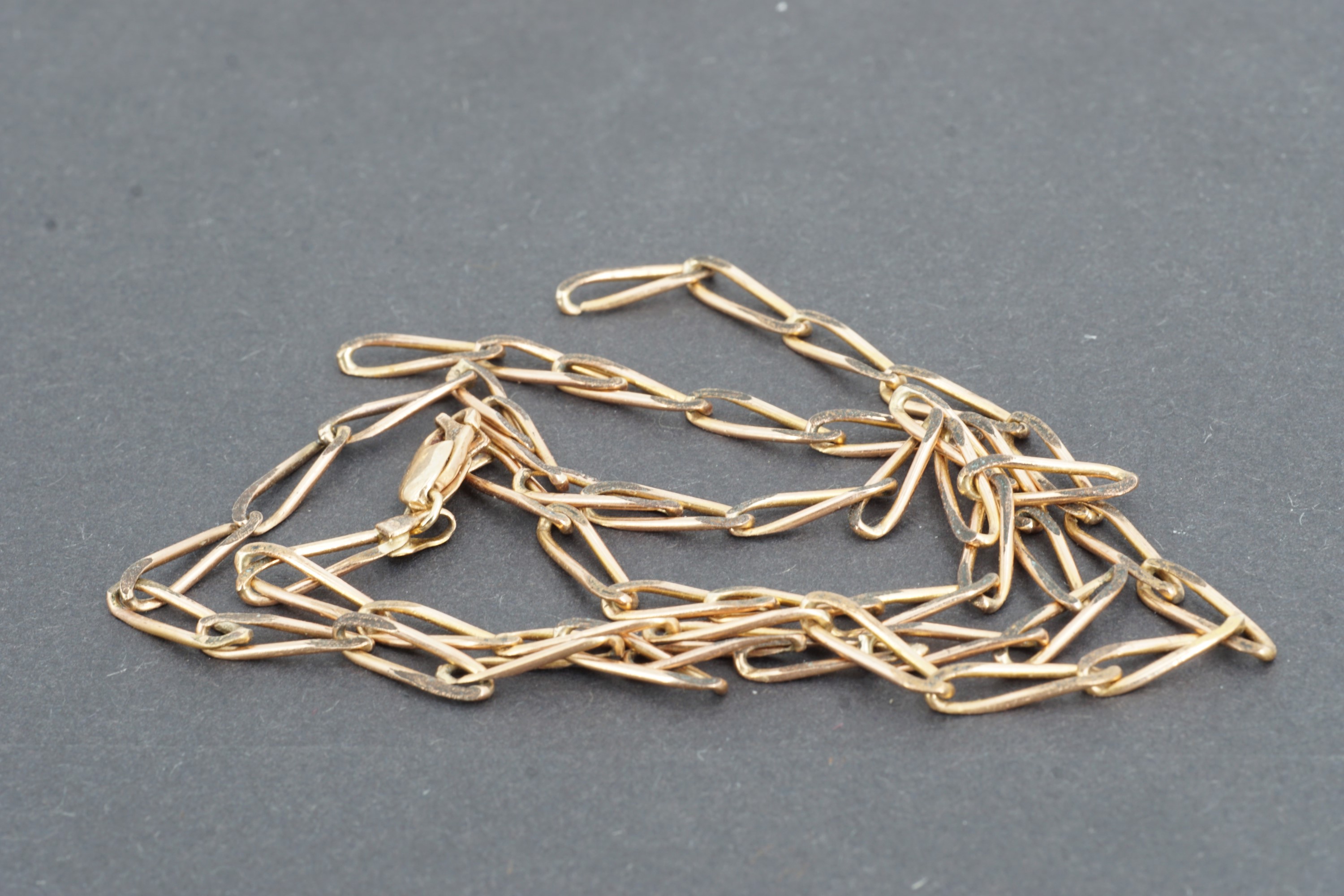 A yellow metal elongated curb link neck chain, (a/), 56 cm, 9.8 g