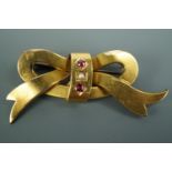 An antique 15ct gold brooch in the form of a ribbon bow, set with a seed pearls and rubies, 4 cm,