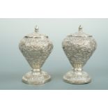 A pair of Anglo-Indian white metal pepperettes, each of inverted baluster form over a spreading