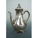 A Victorian silver coffee pot, of gadrooned baluster form, raised over four volute scrolling feet,