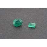 Two unmounted / loose emeralds, one oval cut of approximately .52ct, the other emerald cut and of