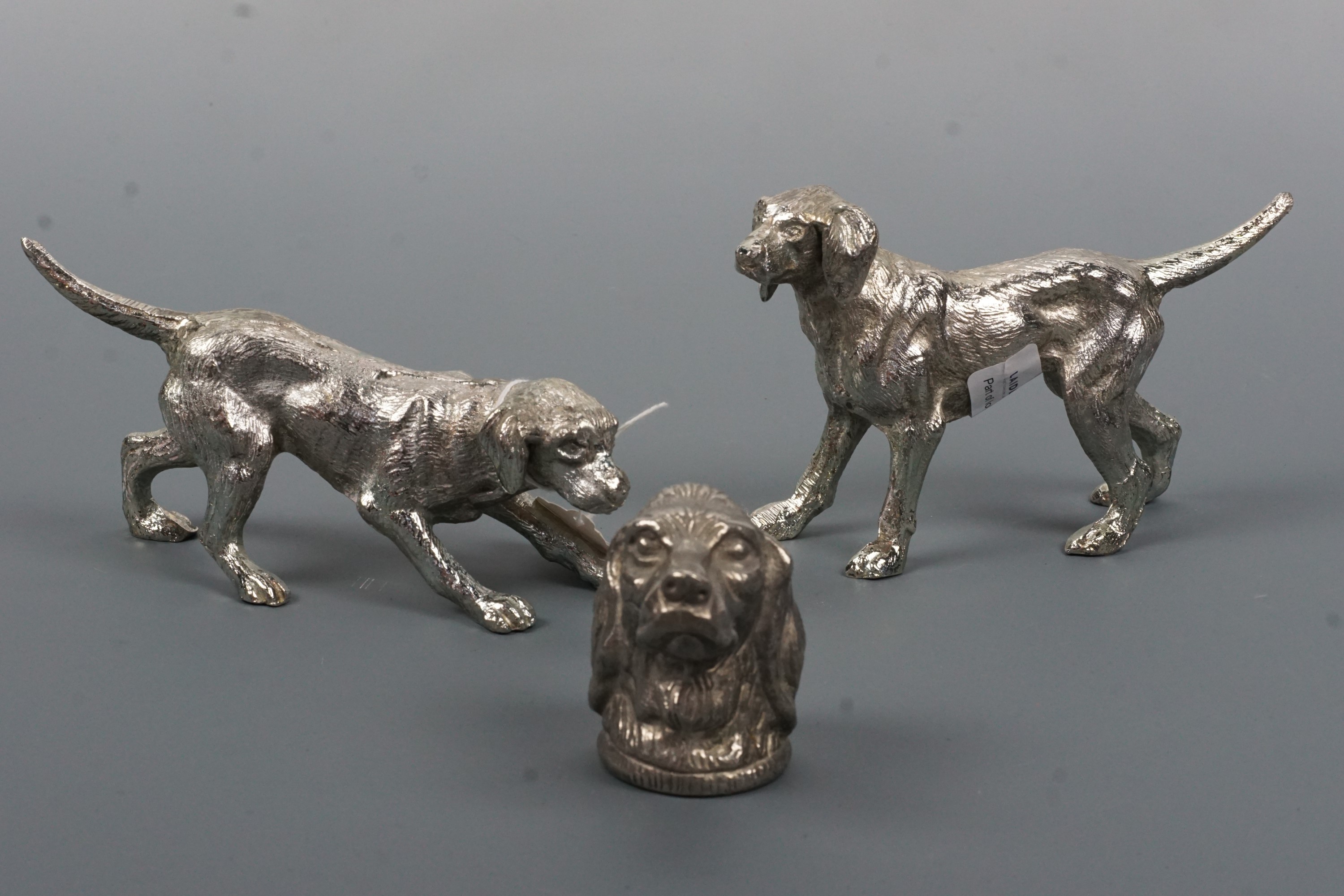 Two cast dog figurines and a cast dog's head